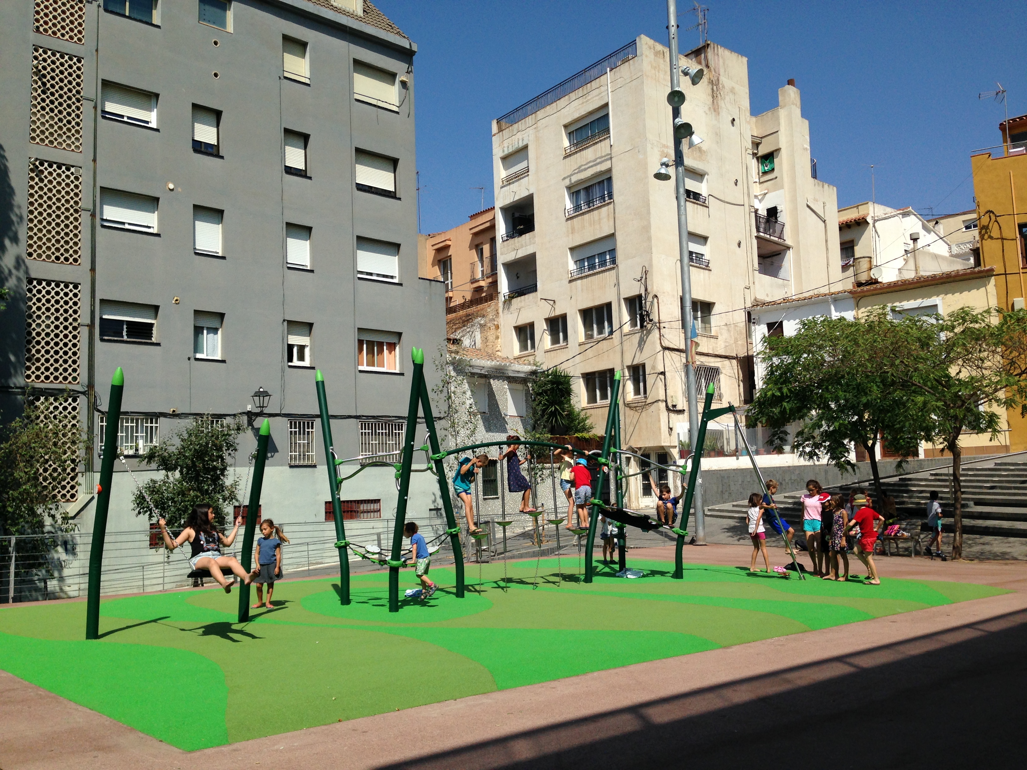 Nens i nenes del casal de Blancdeguix gaudeixen de la nova àrea de jocs de la plaça del Mercat Vell.